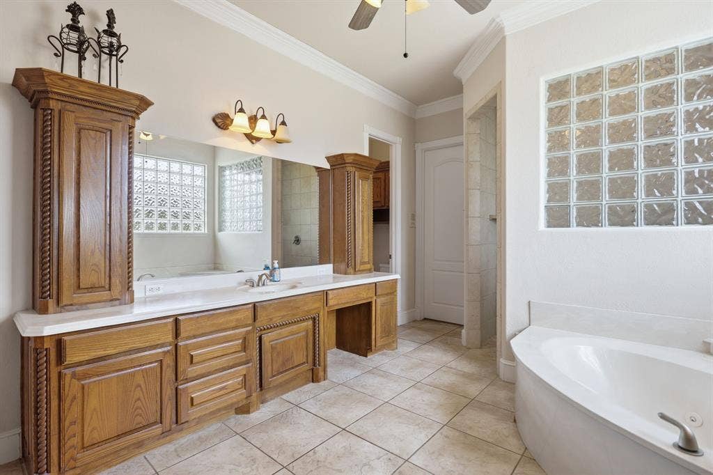5030 Monroe Court, Midlothian, TX 76065 Expansive vanity with wood-finish cabinetry, dual sinks, and white countertops