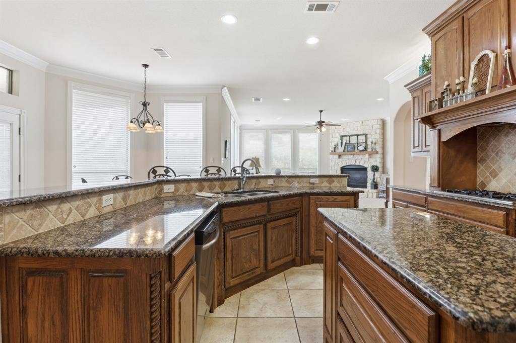 5030 Monroe Court, Midlothian, TX 76065 Kitchen featuring granite countertops, wood cabinetry, tile flooring, and a tile backsplash