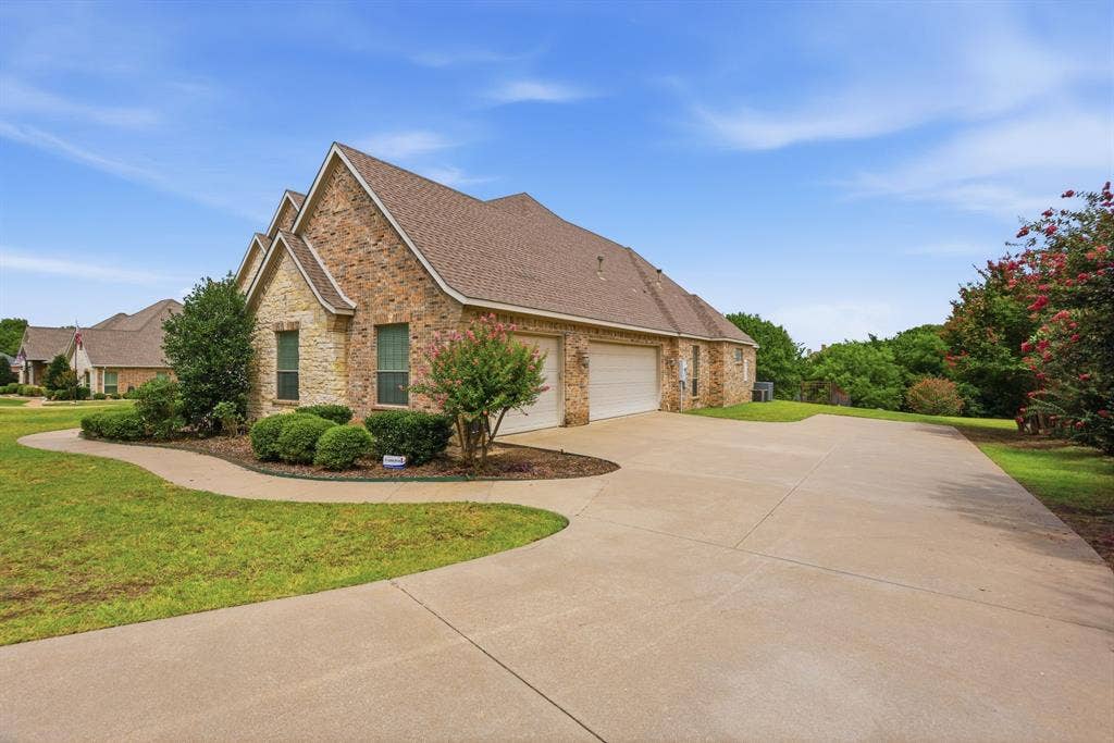 5030 Monroe Court, Midlothian, TX 76065 Brick and stone exterior with architectural gables, a two-car garage, and a concrete driveway