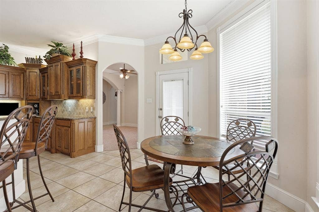 5030 Monroe Court, Midlothian, TX 76065 Kitchen dining area featuring a pendant chandelier, large window with blinds, and tile flooring