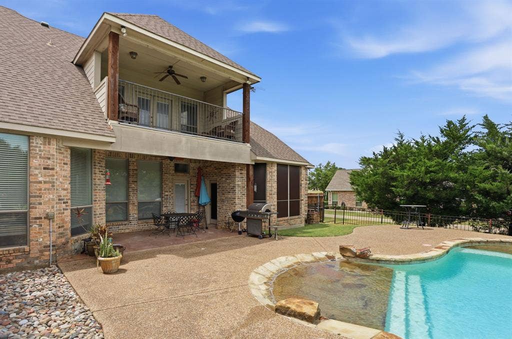 5030 Monroe Court, Midlothian, TX 76065 Custom-shaped swimming pool with an integrated spa, bordered by a stone coping