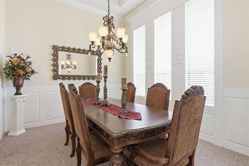 5030 Monroe Court, Midlothian, TX 76065 Formal dining area featuring a decorative chandelier, wainscoting, crown molding, and multiple tall windows