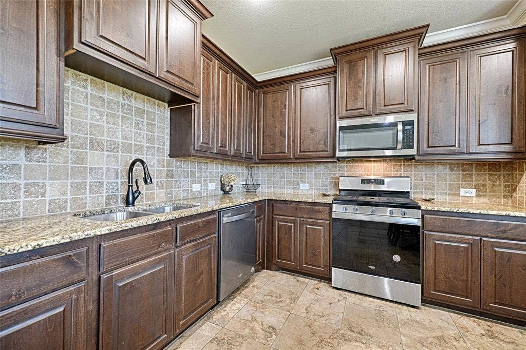 Kitchen featuring rich wood cabinetry, patterned tile backsplash, and light-toned countertops