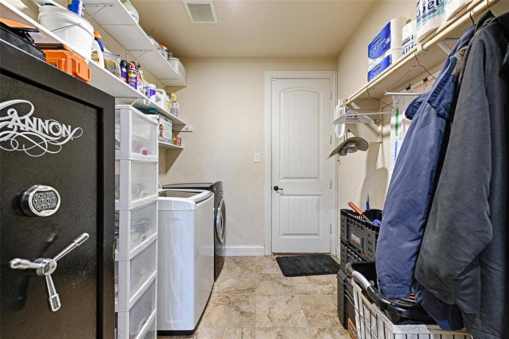Utility room featuring patterned tile flooring, a paneled door, and built-in shelving