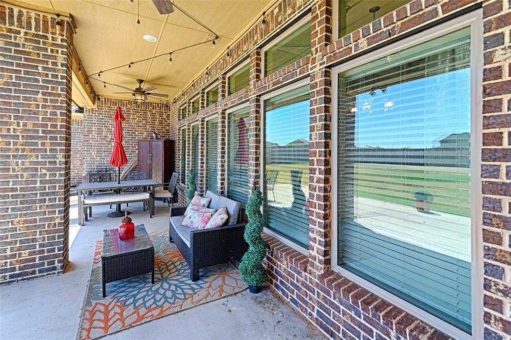 Covered patio featuring a brick exterior and concrete flooring