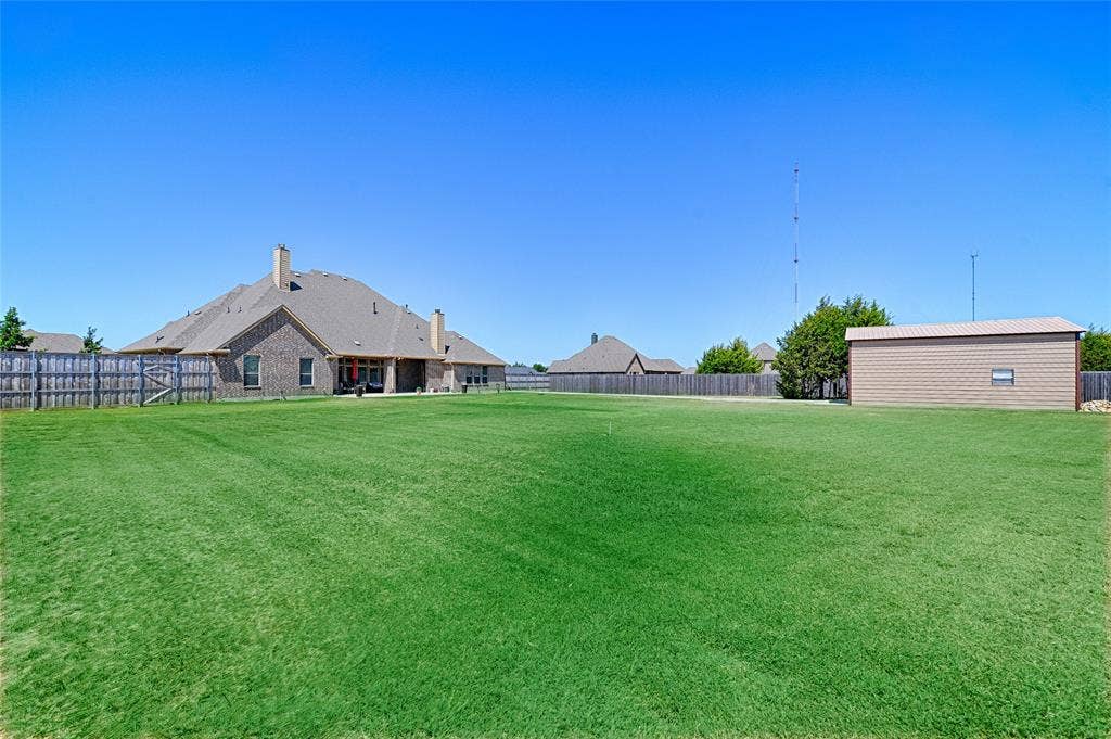 Expansive rear lawn with a privacy fence
