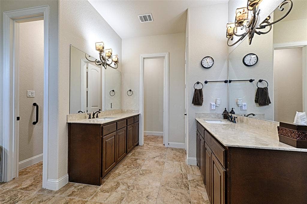 Bathroom featuring a spacious dual vanity with dark wood cabinetry and light-toned countertops