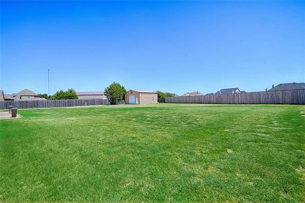 Expansive green lawn, bordered by a substantial privacy fence