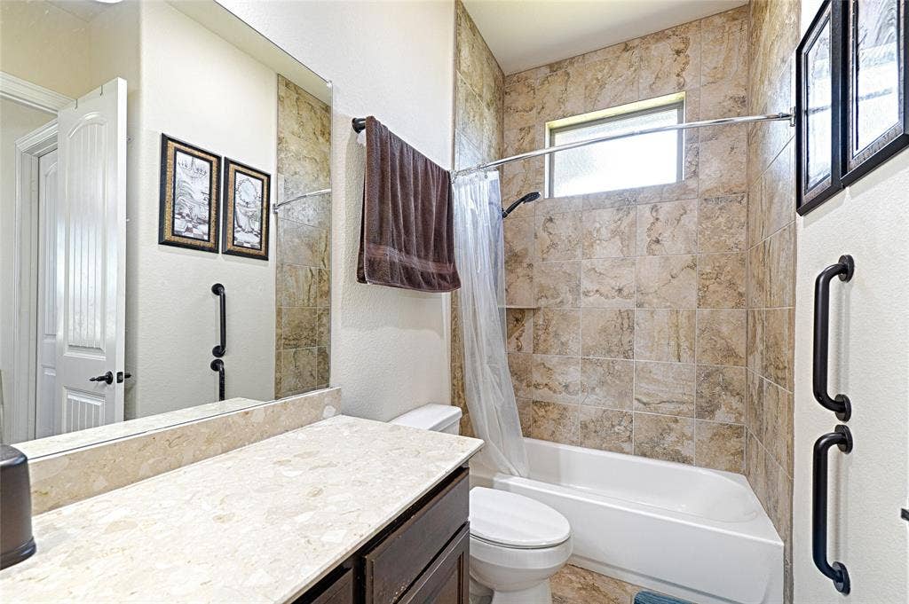 Bathroom featuring a white tub, stone-patterned tile shower surround with a recessed niche, and a frosted window