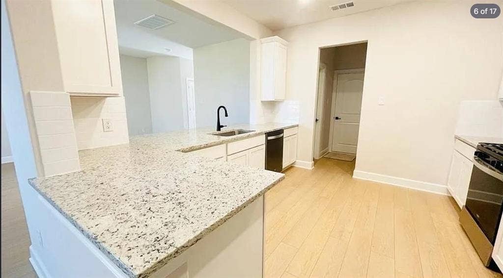 1323 windermere Way, Princeton, TX 75407 Kitchen featuring light wood-finish flooring, white cabinetry, speckled countertops, stainless steel appliances, and a subway tile backsplash