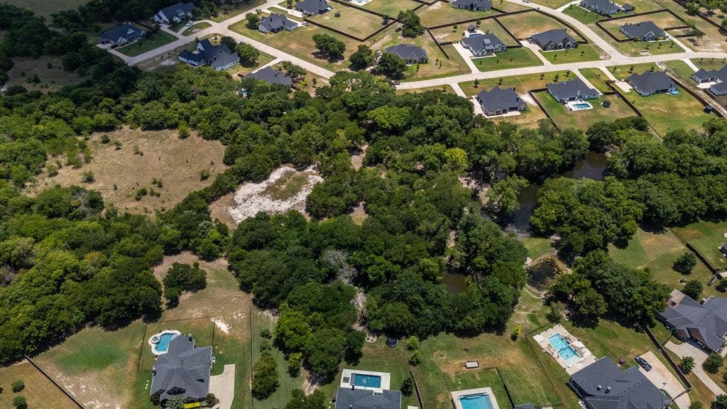 Expansive undeveloped land featuring mature trees and a natural water feature