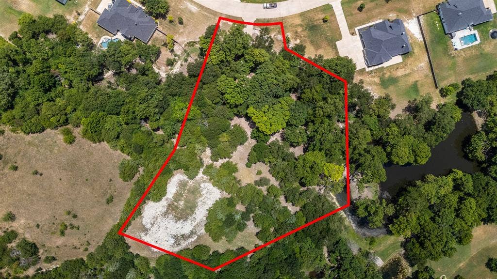 Expansive wooded lot with varied terrain, featuring mature trees and clearings