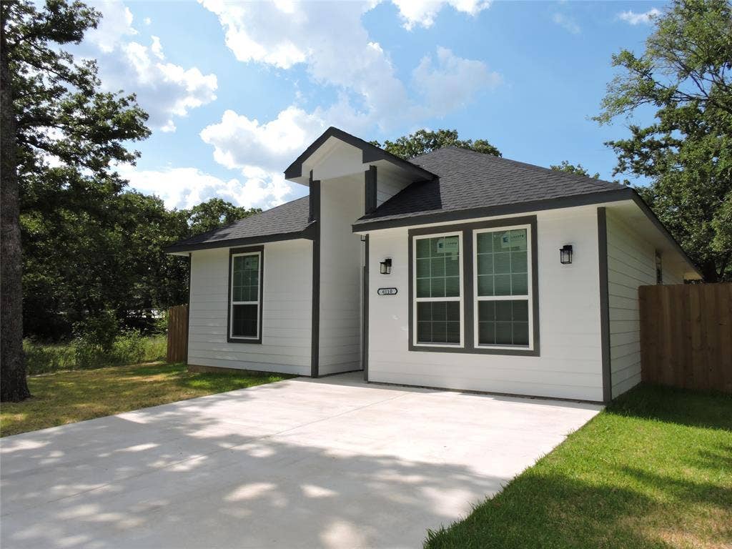 6110 Tejas Drive, Mabank, TX 75156 Contemporary single-story residence featuring white horizontal siding, dark trim, a gabled roofline, twin front windows, and a concrete driveway
