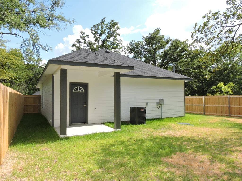 6110 Tejas Drive, Mabank, TX 75156 Rear exterior featuring white siding, a dark asphalt shingle roof, and a covered concrete patio