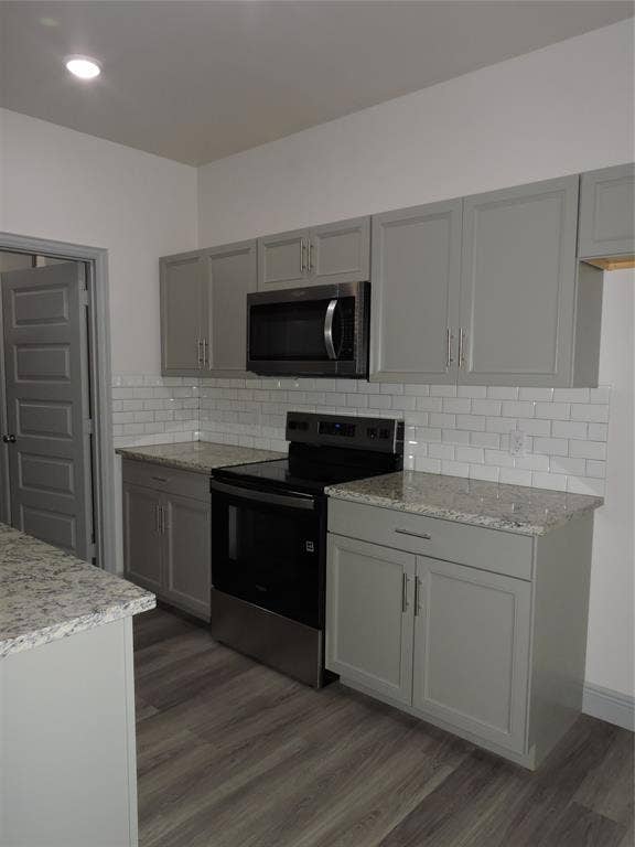 6110 Tejas Drive, Mabank, TX 75156 Kitchen featuring light gray cabinetry, stainless steel appliances, granite countertops, subway tile backsplash, and wood-finish flooring