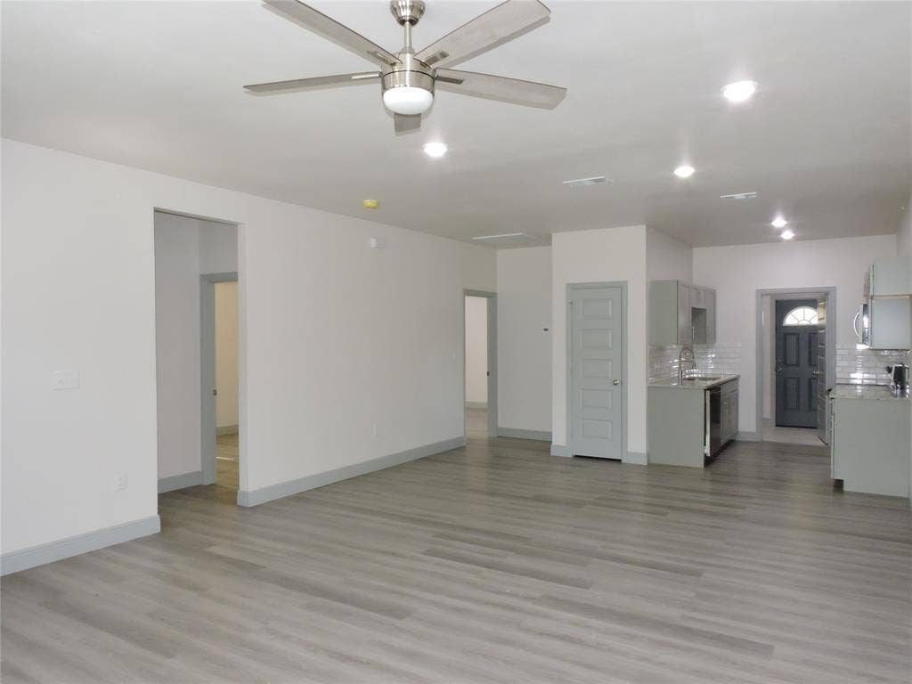 6110 Tejas Drive, Mabank, TX 75156 Open-concept living space featuring wood-finish flooring, recessed lighting, a modern ceiling fan, gray trim, and a kitchen with gray cabinetry, subway tile backsplash, and stainless steel appliances