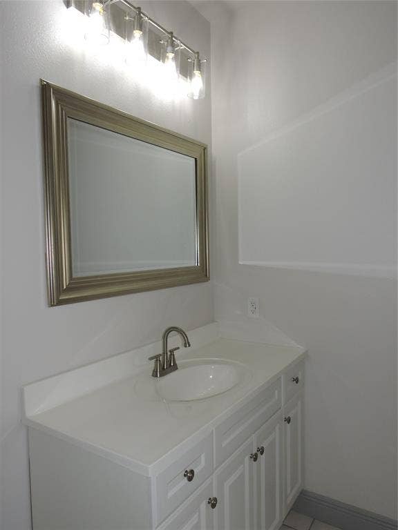 6110 Tejas Drive, Mabank, TX 75156 Vanity with a white countertop and integrated sink, brushed nickel faucet, and white cabinet storage with decorative pulls