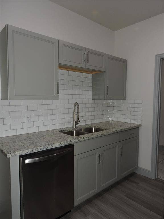 6110 Tejas Drive, Mabank, TX 75156 Kitchen counter featuring light gray cabinetry with brushed nickel hardware, a stainless steel double basin sink with gooseneck faucet, light granite-style countertops, and a white subway tile backsplash