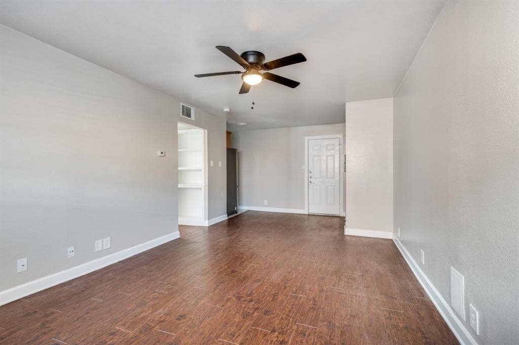 4915 Reiger Avenue, #D, Dallas, TX 75214 Expansive living area with wood-finish flooring, light gray walls, and white baseboards