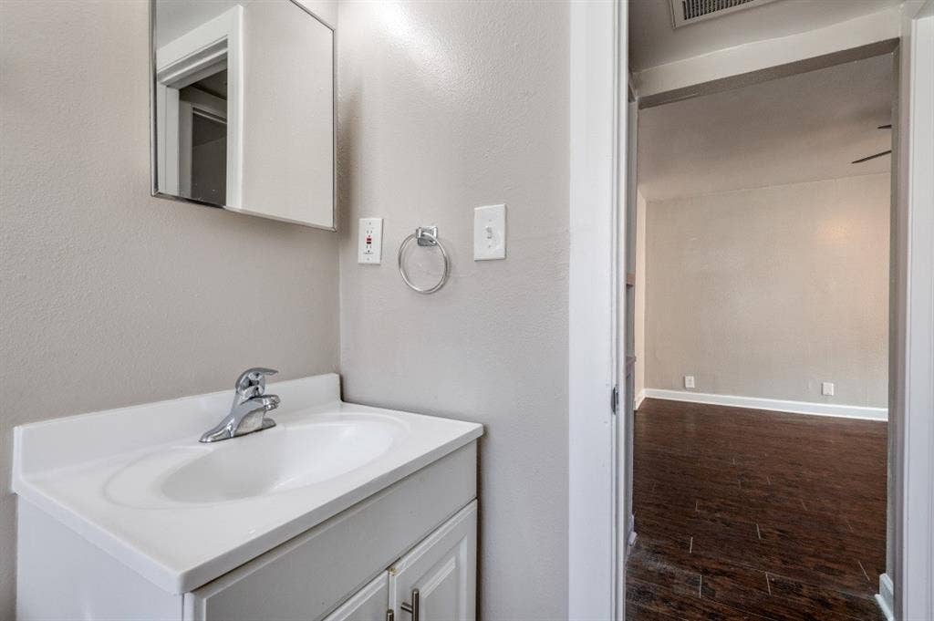 4915 Reiger Avenue, #D, Dallas, TX 75214 Bathroom vanity with integrated sink, chrome faucet, and mirrored medicine cabinet