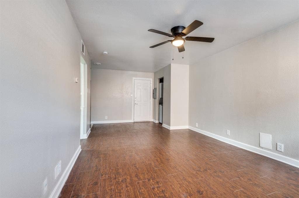 4915 Reiger Avenue, #D, Dallas, TX 75214 Spacious interior featuring wood-finish flooring, light grey wall paint, and white baseboards