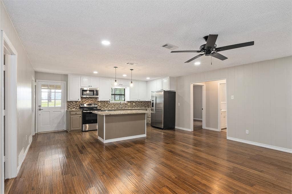 243 Shoreline Drive, Star Harbor, TX 75148 Wide and open kitchen floorplan with all new SS appliances, can lighting, granite counters and large island with storage. 42" cabitets.