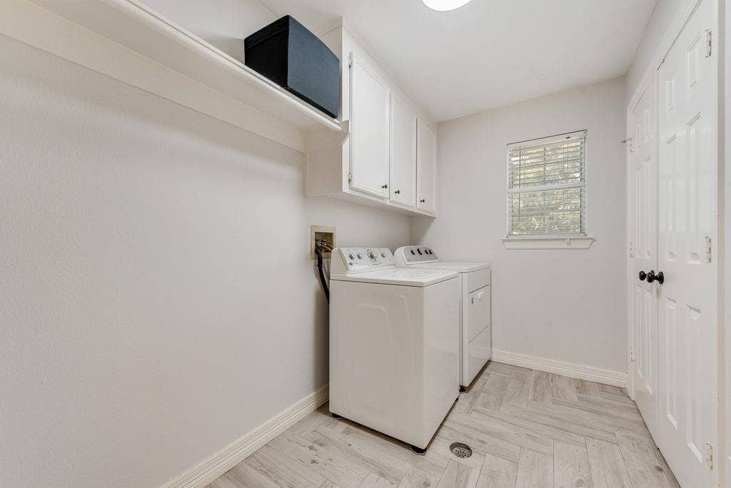 Laundry room has a closet and cabinets and is conveniently located on the second story close to the bedrooms.
