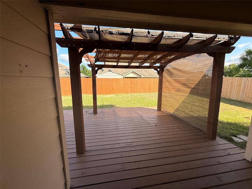2004 Samantha Lane, Heartland, TX 75126 Wood-finish deck with a pergola featuring a mesh canopy and partial mesh side panels