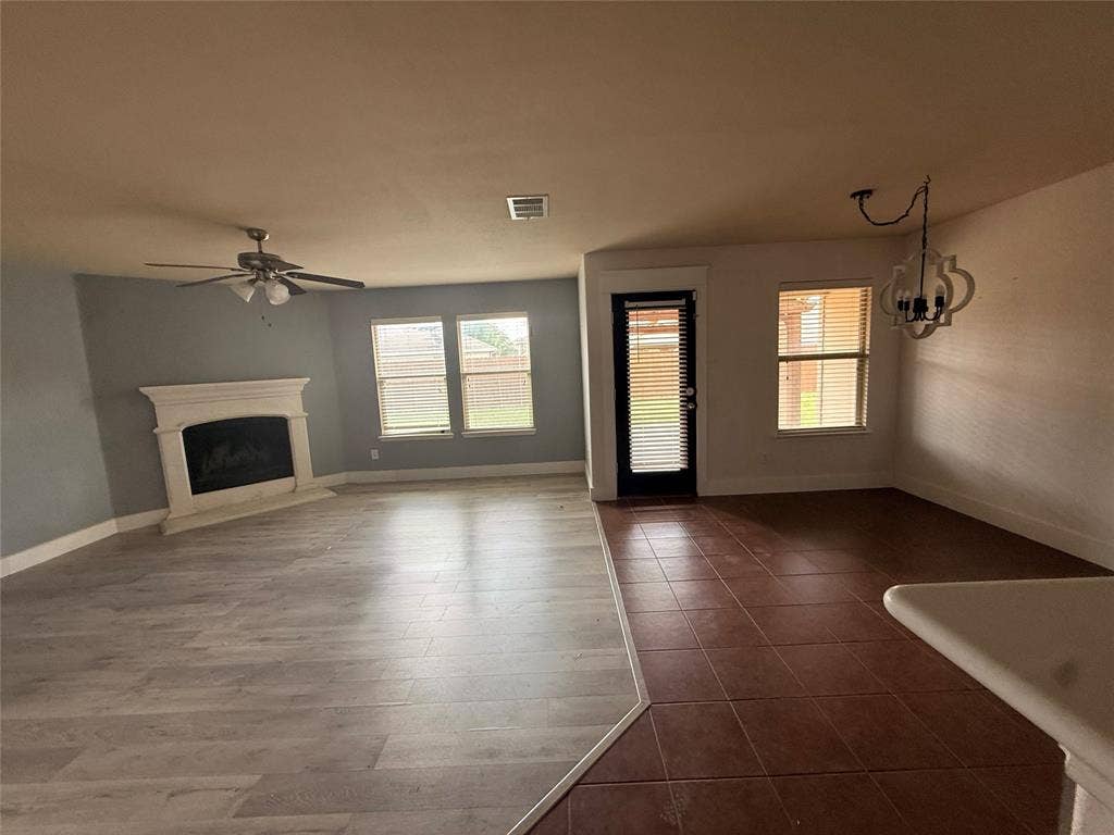 2004 Samantha Lane, Heartland, TX 75126 Open-concept living area featuring wood-finish flooring, a white mantel fireplace, and a ceiling fan