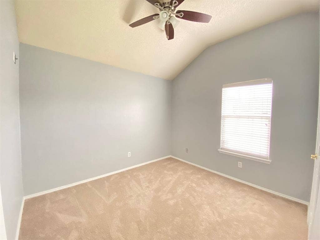 1328 Falcon Hollow, Cedar Hill, TX 75104 Room featuring a vaulted ceiling with a ceiling fan, light gray walls, and beige carpeting