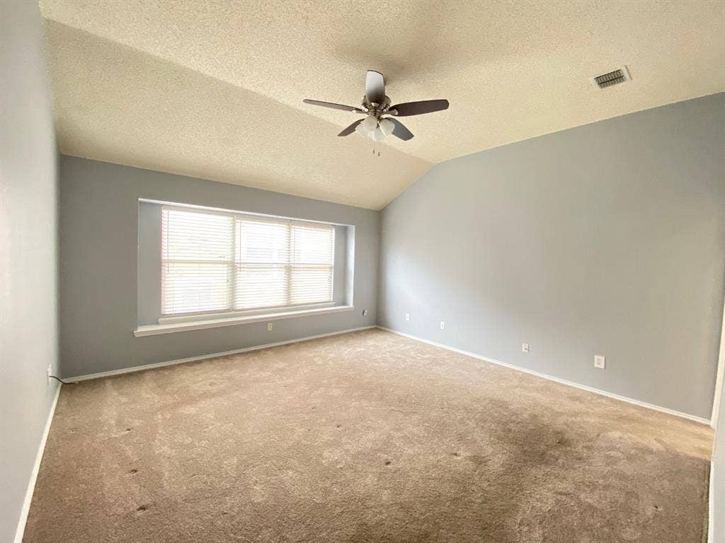 1328 Falcon Hollow, Cedar Hill, TX 75104 Spacious room featuring vaulted ceilings, a ceiling fan with integrated lighting, and a large window with blinds providing natural illumination