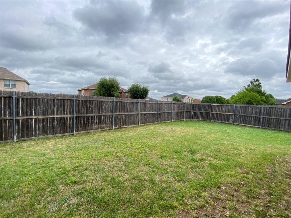 1328 Falcon Hollow, Cedar Hill, TX 75104 Expansive backyard featuring a manicured lawn and tall wooden privacy fencing