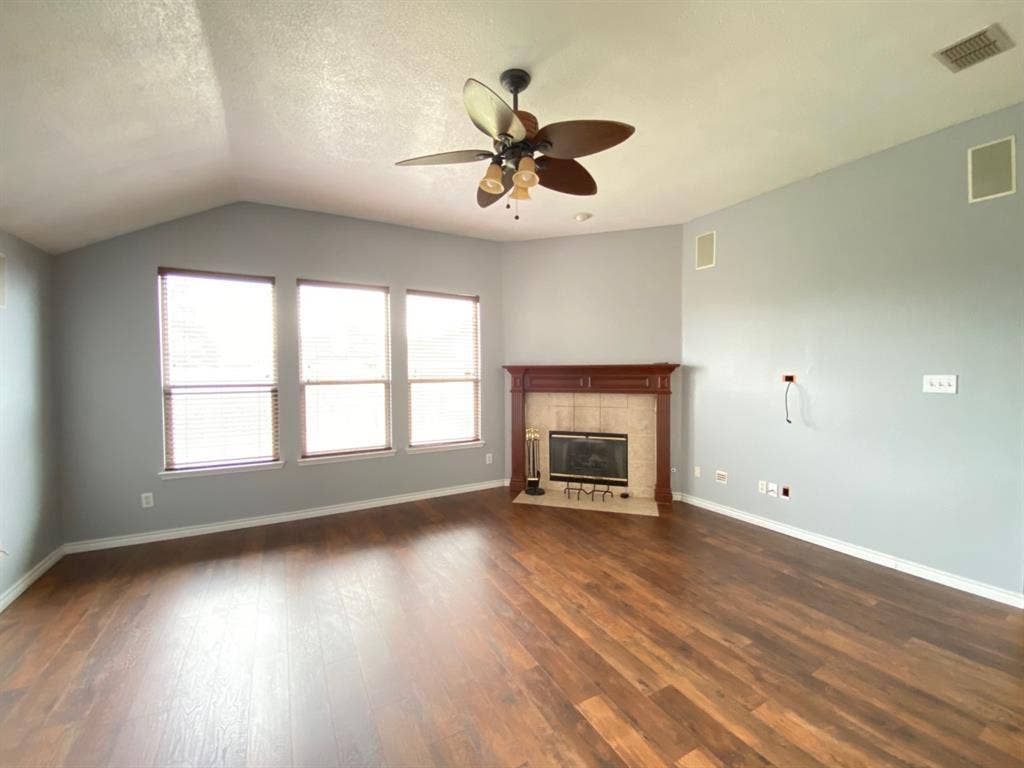 1328 Falcon Hollow, Cedar Hill, TX 75104 Living space featuring wood-finish flooring, a vaulted ceiling, and a ceiling fan with integrated lighting
