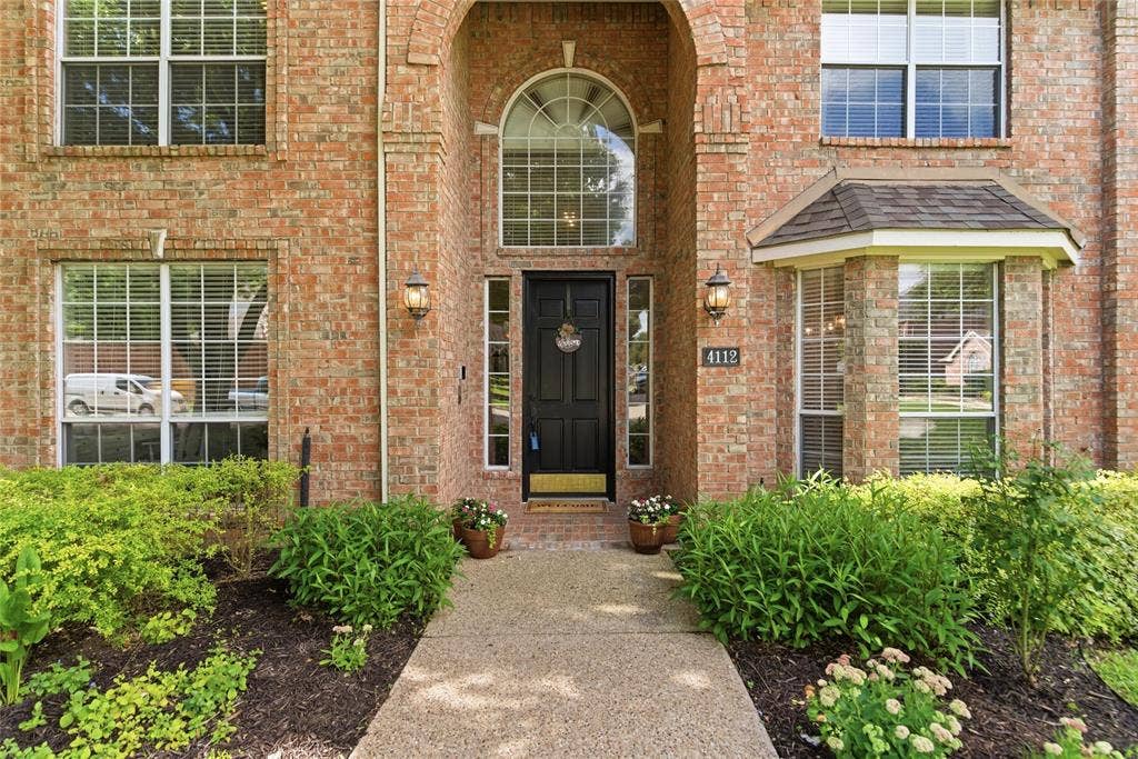 4112 Blackpool Drive, Plano, TX 75093 Brick exterior with an arched entry, a black front door, and an arched transom window