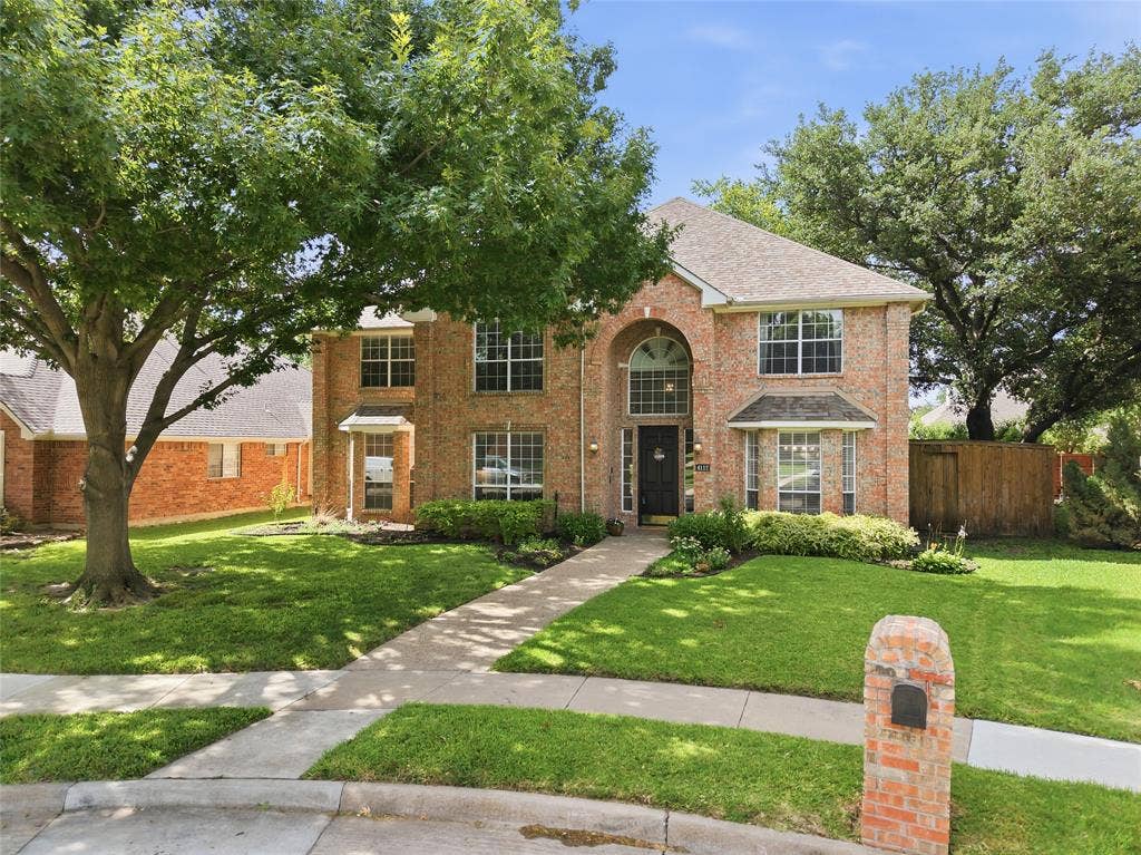 4112 Blackpool Drive, Plano, TX 75093 Two-story brick facade residence with an arched entry, bay window, and gabled roof