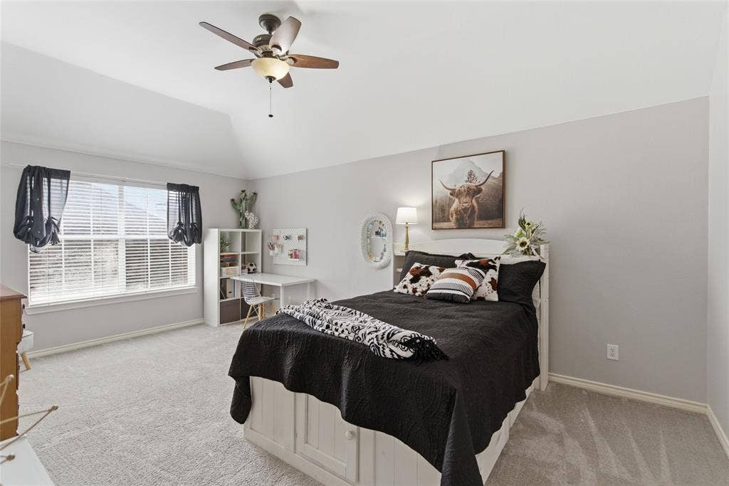 4112 Blackpool Drive, Plano, TX 75093 Spacious room featuring vaulted ceilings, a large window with blinds, carpeted flooring, a ceiling fan with integrated lighting, and a built-in bed frame with storage