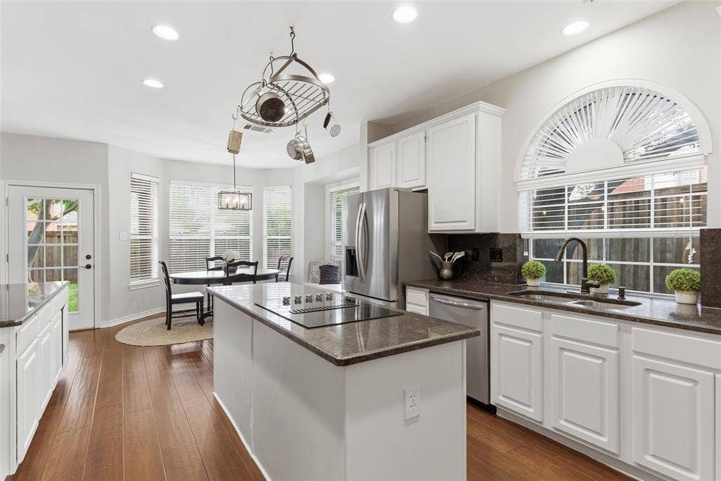 4112 Blackpool Drive, Plano, TX 75093 Contemporary kitchen featuring wood-finish flooring and white cabinetry