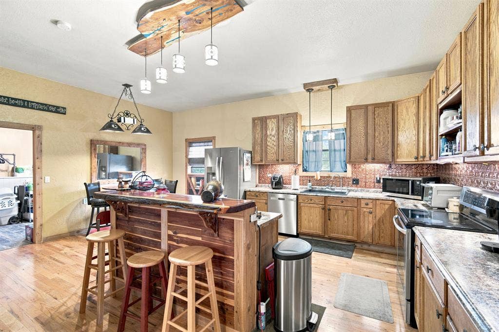 Kitchen features a custom built bar with cedar counter top and front. Notice the custom made light fixture also.  All trim thoughout is cedar.