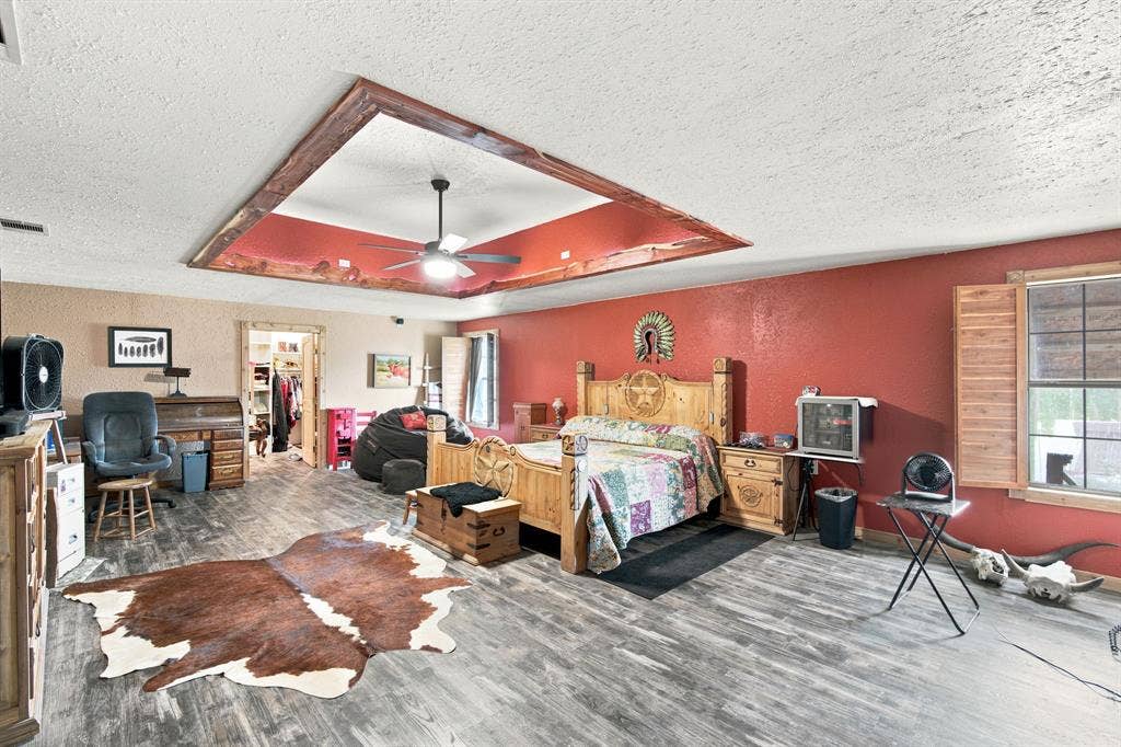 Huge 28' X 18' Primary bedroom features ceiling treatment with ceiling fan and shutters for windows.