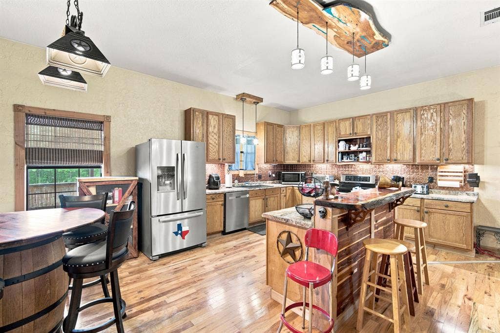 Kitchen has stainless dishwasher and range and a farm sink along with lots of cabinets. Dining area is to the side of the large kitchen.