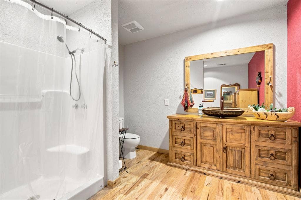 Hall bath with large shower and custom wood trim and stylish bowl sink