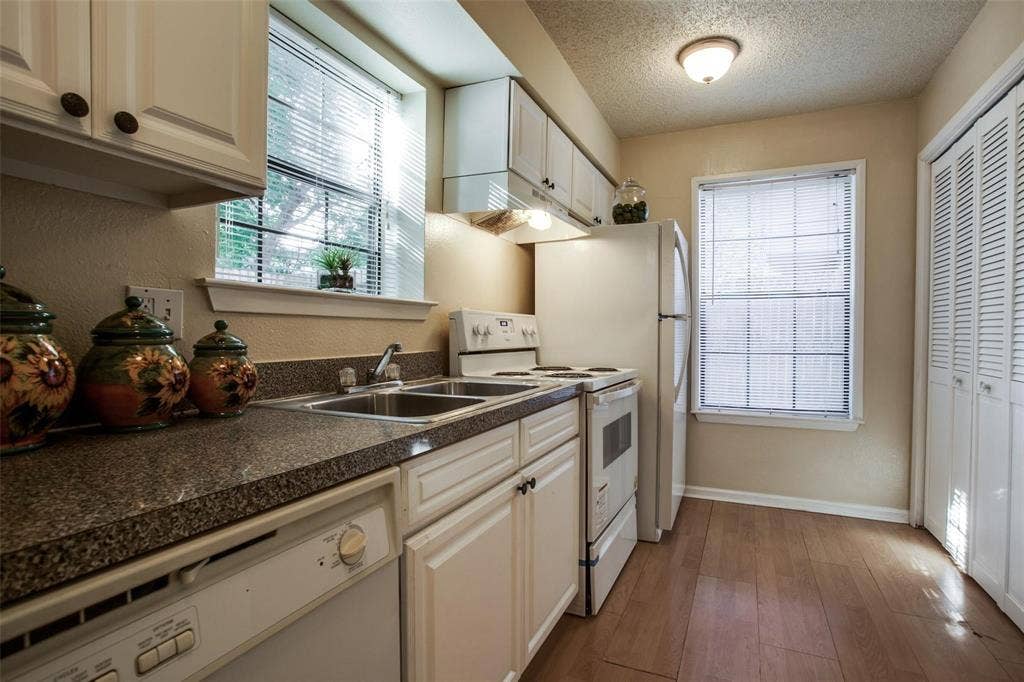 5322 Columbia Avenue, Dallas, TX 75214 A bright kitchen with pristine white cabinets and a contemporary sink, designed for functionality and aesthetic appeal.