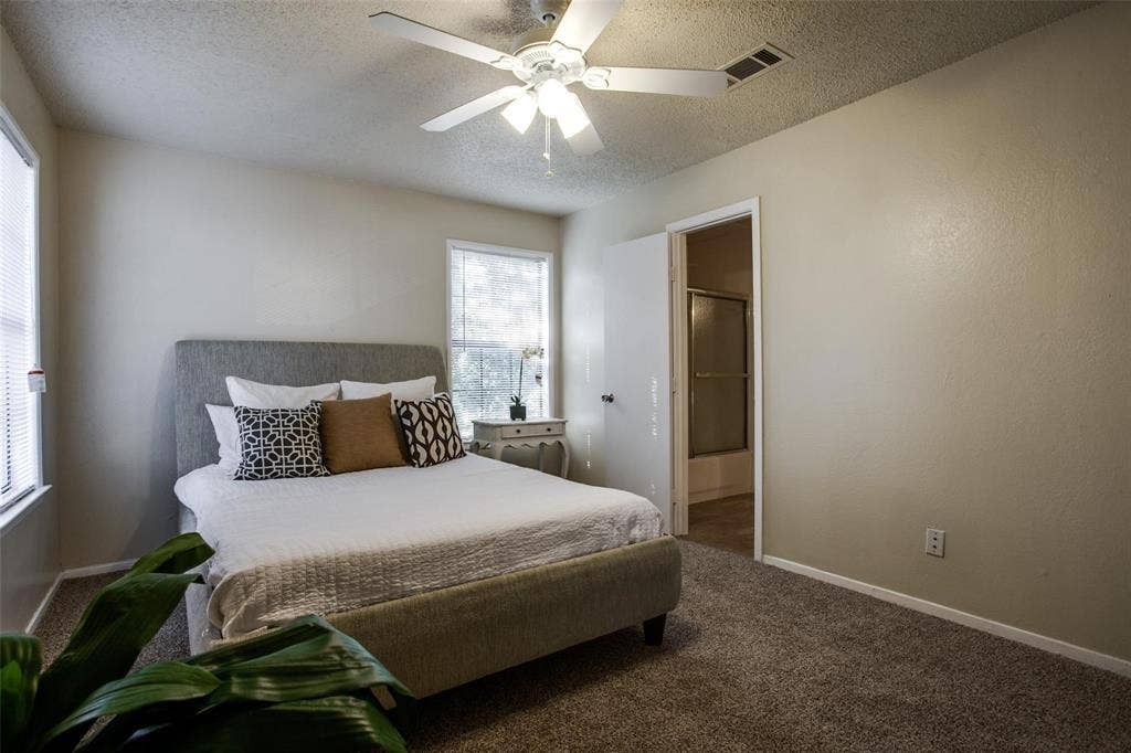 5322 Columbia Avenue, Dallas, TX 75214 A serene bedroom scene showcasing a bed and a ceiling fan, perfect for a peaceful and cool sleeping environment.