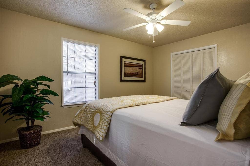 5322 Columbia Avenue, Dallas, TX 75214 A serene bedroom scene with a bed, a ceiling fan and a tall window letting in light.