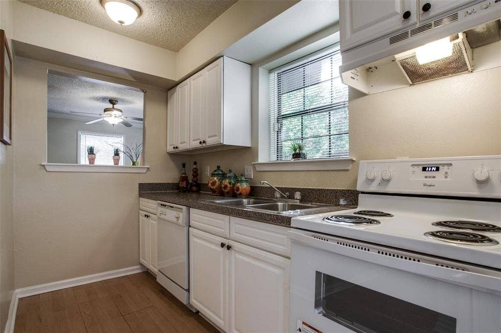 5322 Columbia Avenue, Dallas, TX 75214 A bright kitchen featuring sleek white cabinets and a modern stove, designed for comfort and functionality in cooking.