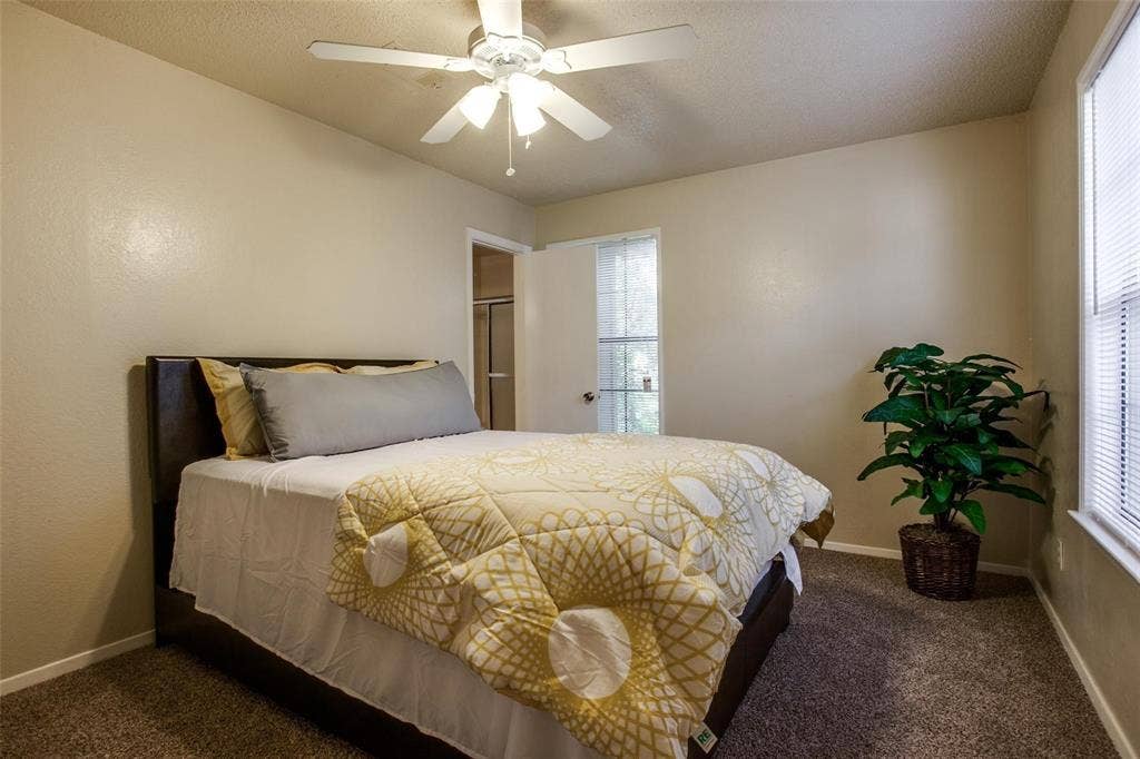 5322 Columbia Avenue, Dallas, TX 75214 Cozy bedroom featuring a bed, tall windows, and a ceiling fan enhancing an airy and comfortable atmosphere.