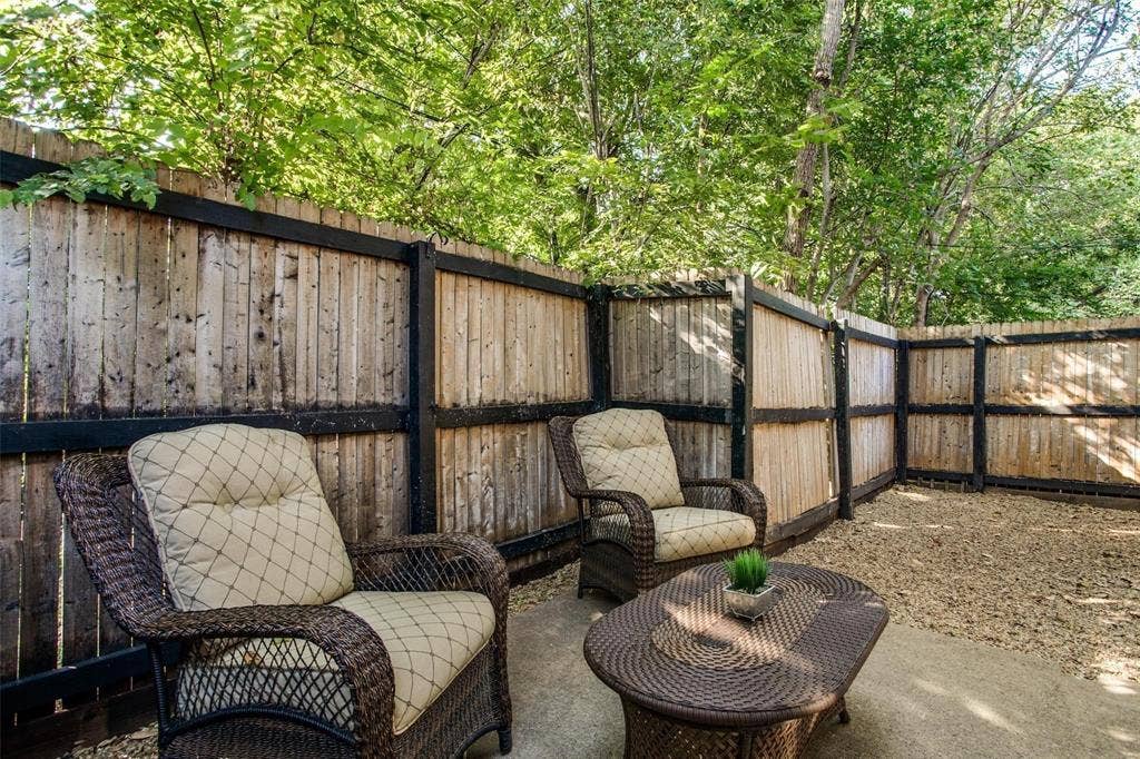 5322 Columbia Avenue, Dallas, TX 75214 A cozy yard featuring a wooden fence and inviting wicker chairs, perfect for relaxation and outdoor gatherings.