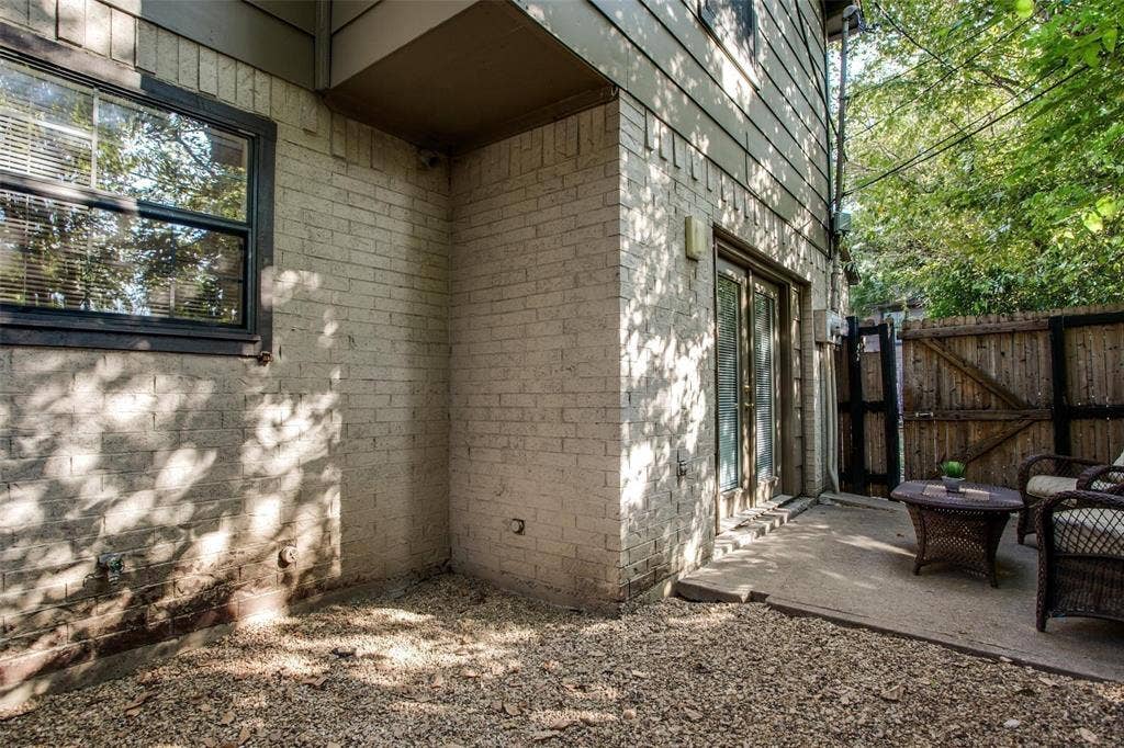5322 Columbia Avenue, Dallas, TX 75214 A cozy patio with chairs and lush trees standing tall in the background, inviting relaxation and tranquility.