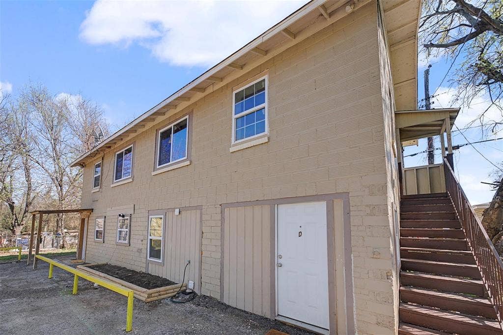 9021 White Settlement Road, #D, White Settlement, TX 76108 Two-story exterior featuring a painted brick facade, multiple windows, and exterior stairs leading to an upper-level entry