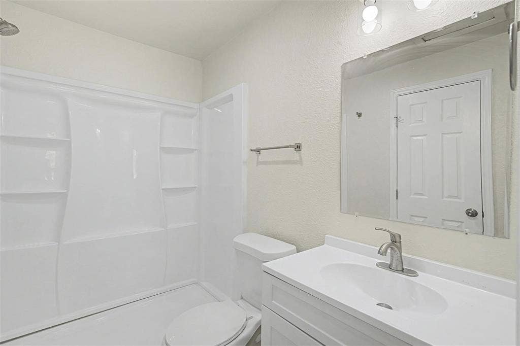 9021 White Settlement Road, #D, White Settlement, TX 76108 Contemporary bathroom featuring a white vanity with integrated sink, brushed nickel faucet, and an expansive wall-mounted mirror